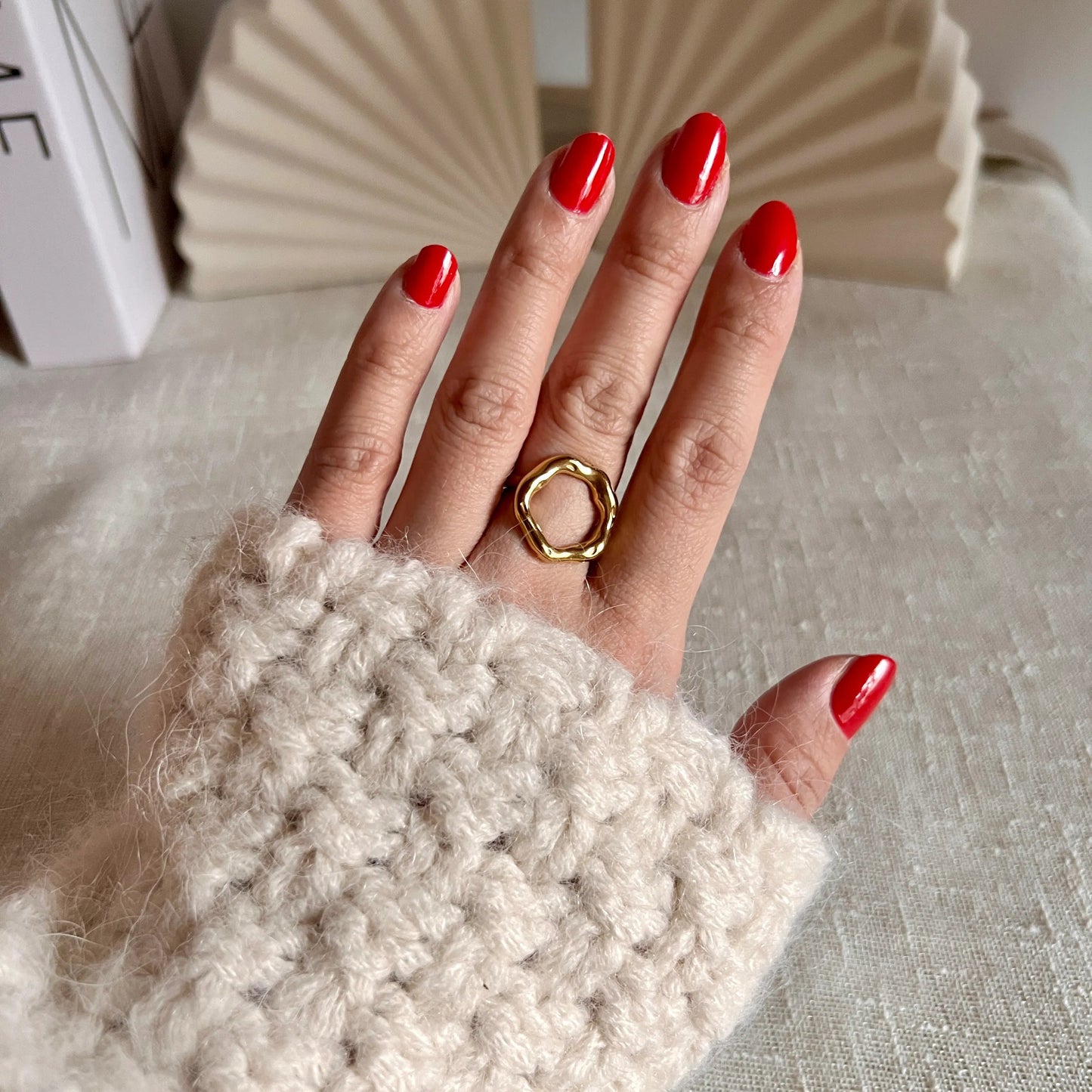 Bague Mon tout, au design cercle martelé en acier inoxydable doré, portée au doigt.