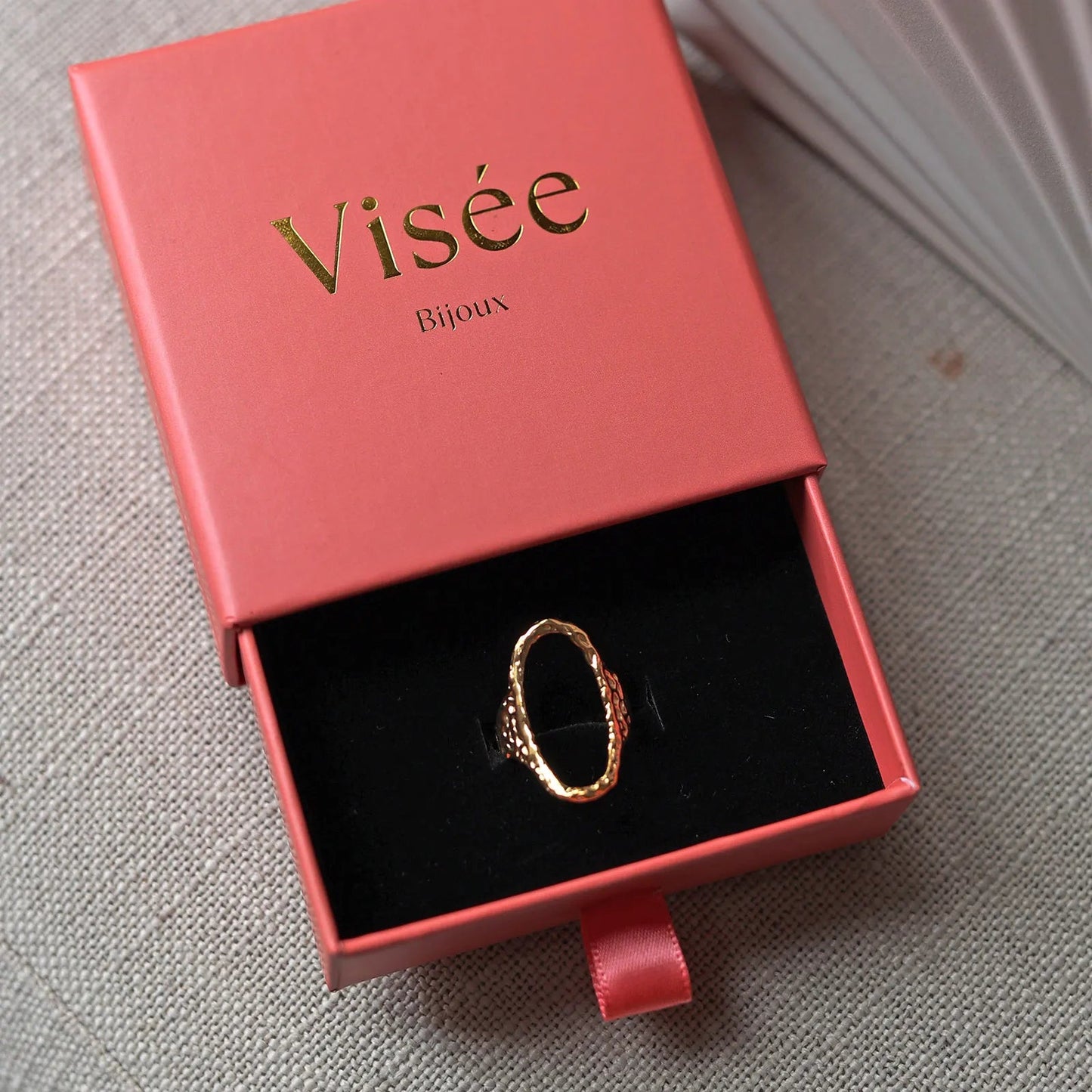 Bague Maintenant en acier inoxydable doré, ovale martelée et réglable, délicatement présentée dans son écrin Visée Bijoux.