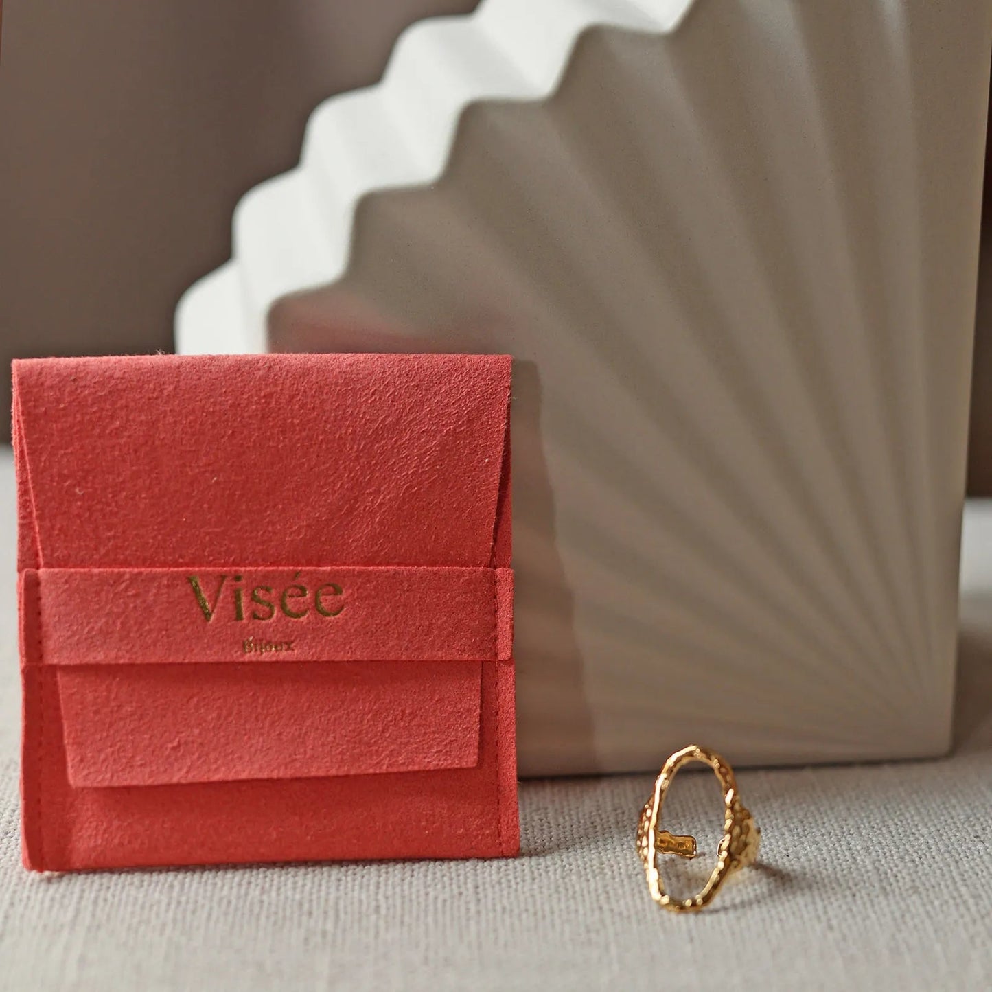 Bague Maintenant en acier inoxydable doré, ovale martelée et réglable, posée près de son pochon Visée Bijoux.