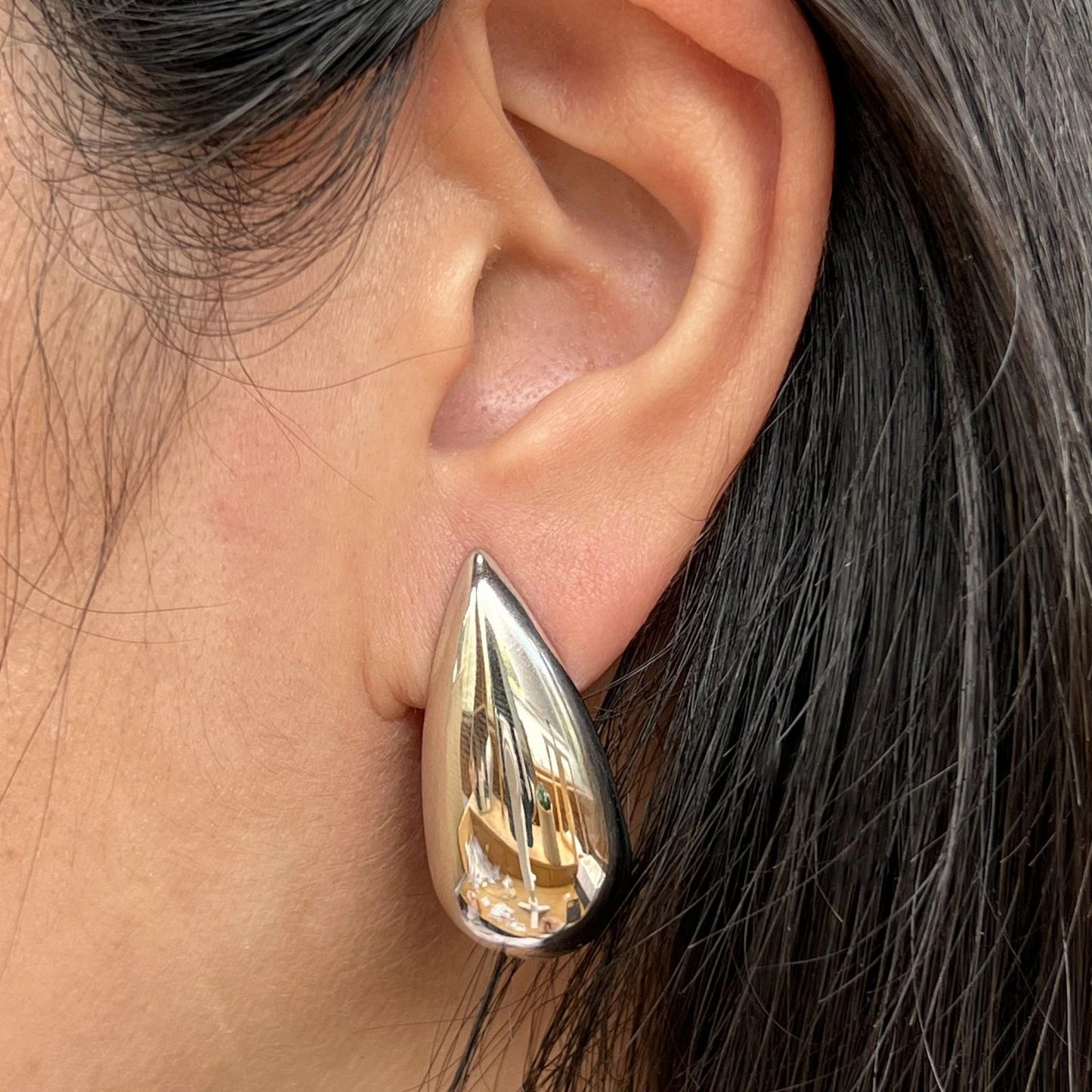 Boucles d'oreilles Larmes assumées en acier inoxydable argenté, forme goutte, portées à l'oreille.