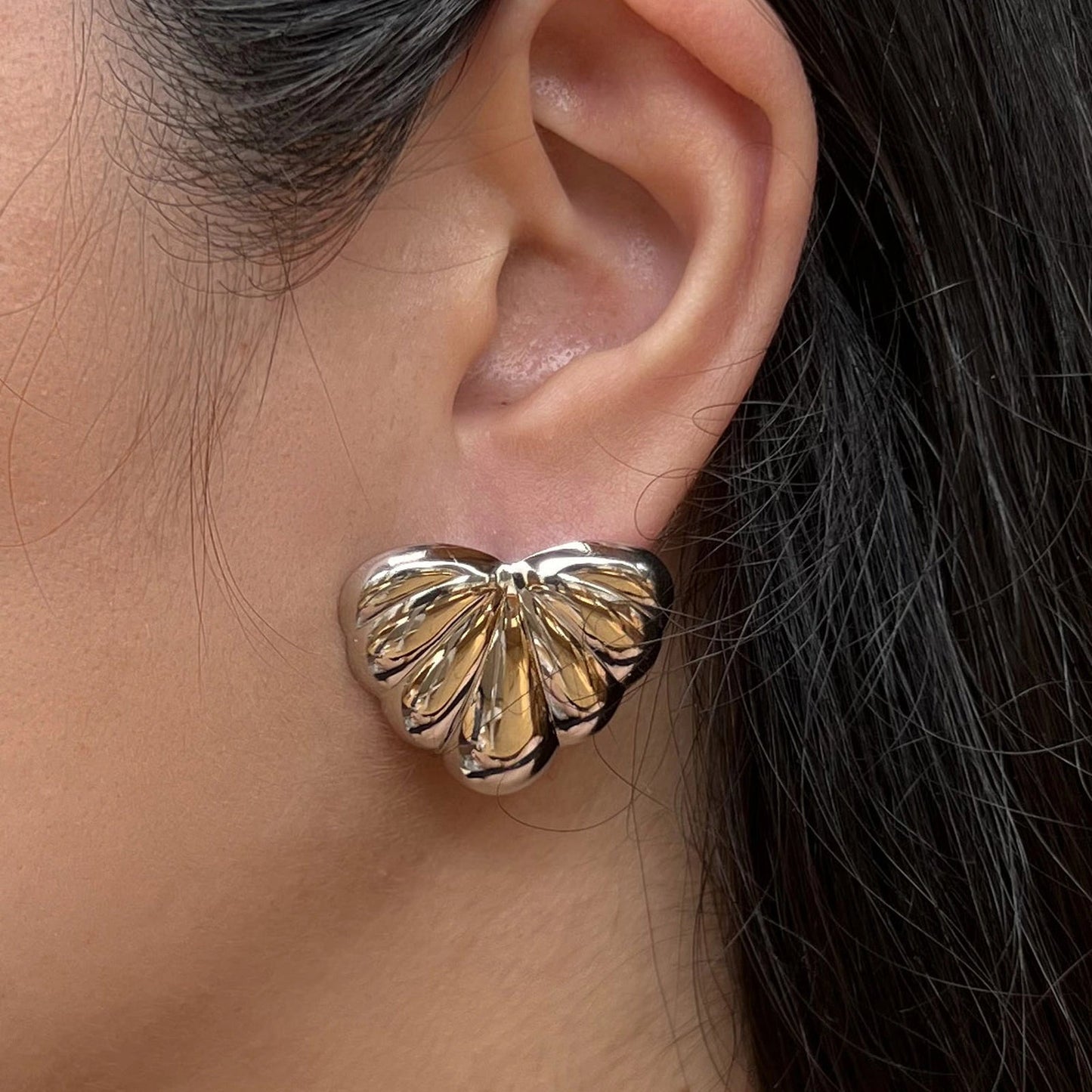 Boucles d'oreilles "Coeur audacieux", en acier inoxydable argenté, au design sculpté en forme de coeur, portées à l'oreille.