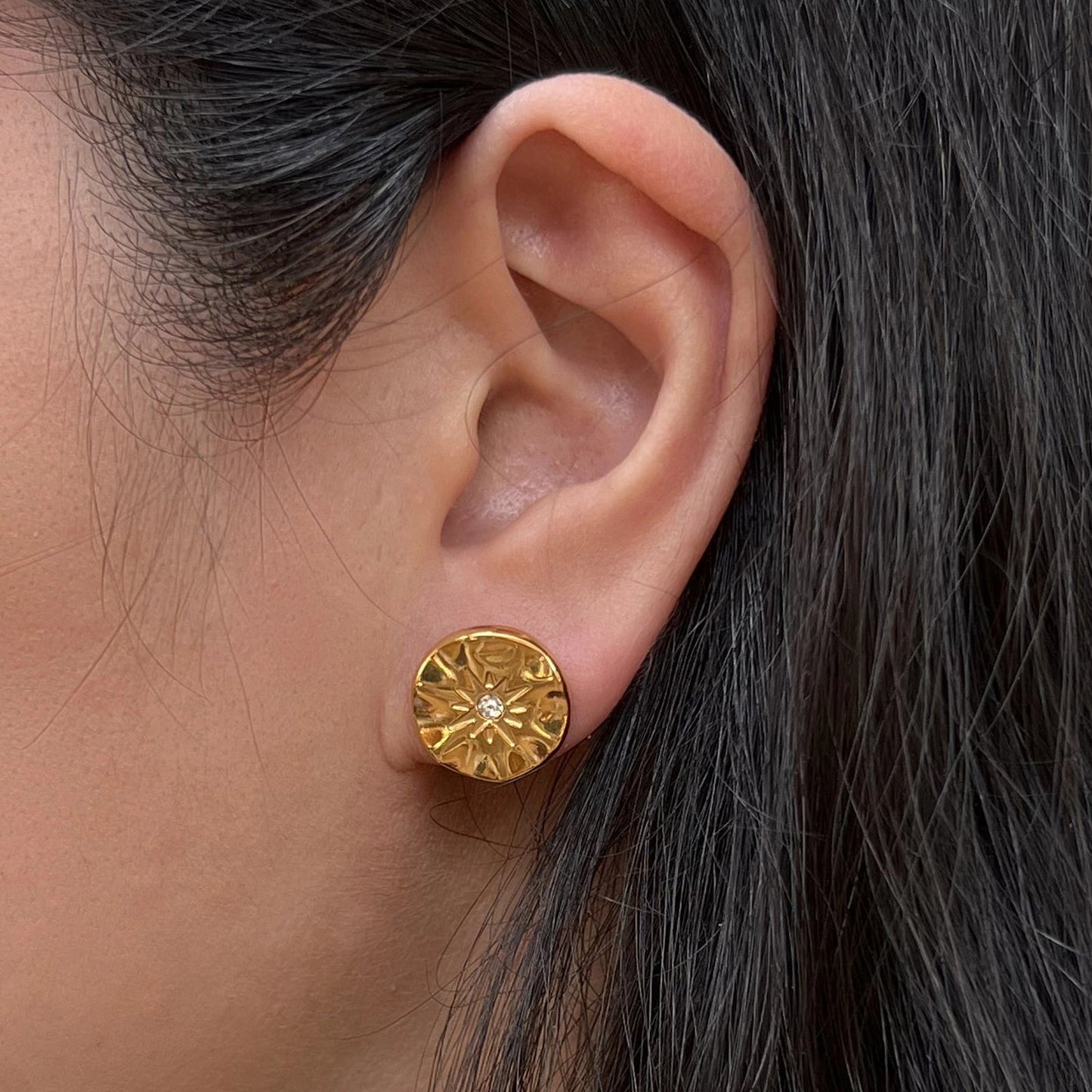 Boucles d’oreilles dorées motif étoile en acier inoxydable, serties d'un zircon lumineux - modèle Céleste porté à l'oreille, par Visée Bijoux.