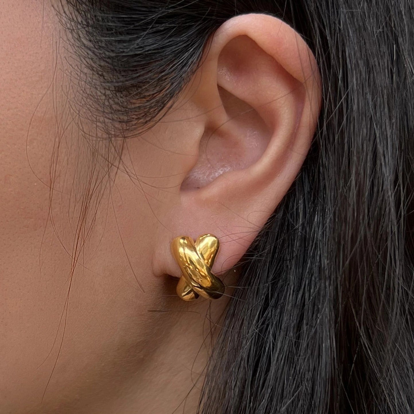 Boucles d'oreilles Révèle toi, design croix en acier inoxydable doré, portées à l'oreille.