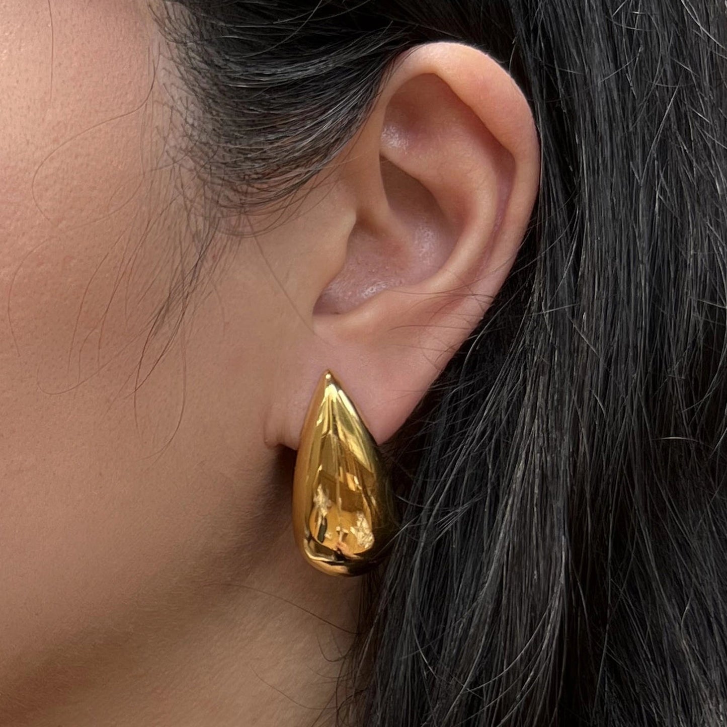 Boucles d'oreilles Larmes assumées en acier inoxydable doré, forme goutte, portées à l'oreille.