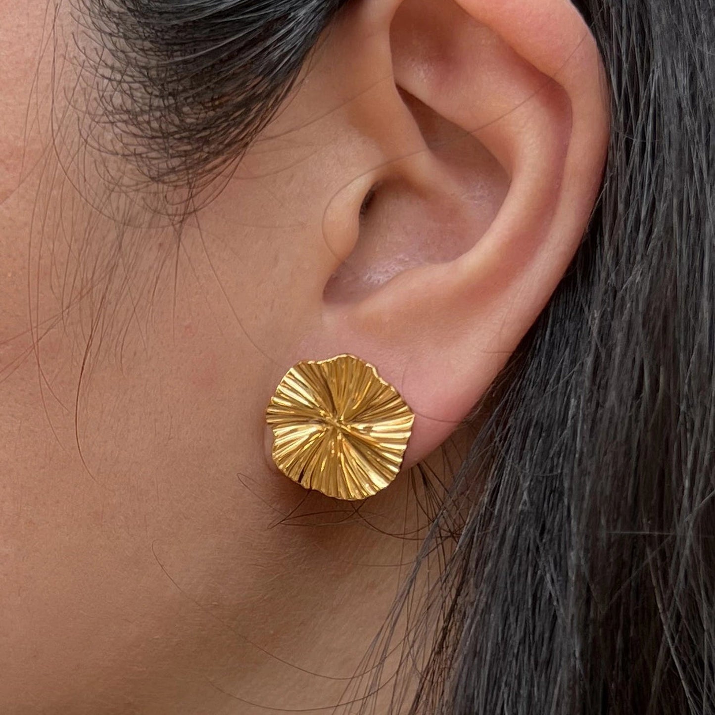 Boucles d'oreilles "Ma raison" en acier doré, au motif floral, portées à l'oreille.