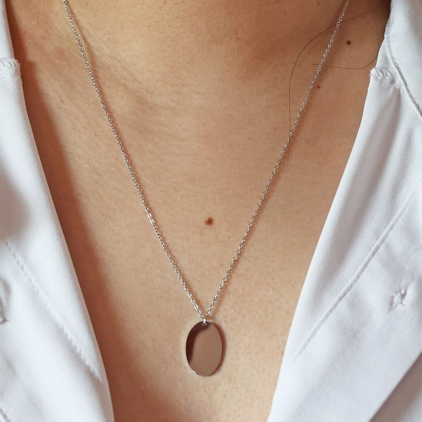 Collier "Tendresse", pendentif ovale personnalisable en acier inoxydable argenté, porté autour du cou.