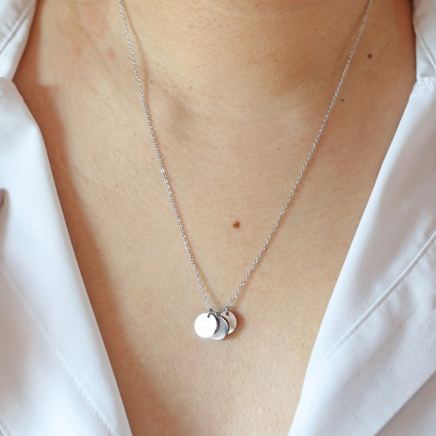 Collier "Inspiration" en acier inoxydable argenté, composé de trois médaillons personnalisables, porté autour du cou.