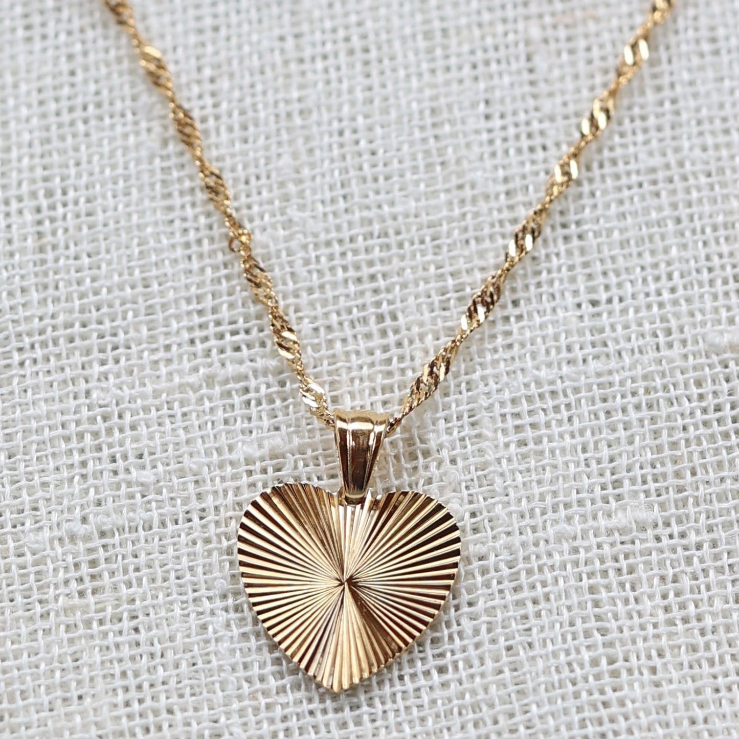 Collier A coeur ouvert en acier doré - vue zoom sur pendentif cœur strié personnalisé et chaîne torsadée.