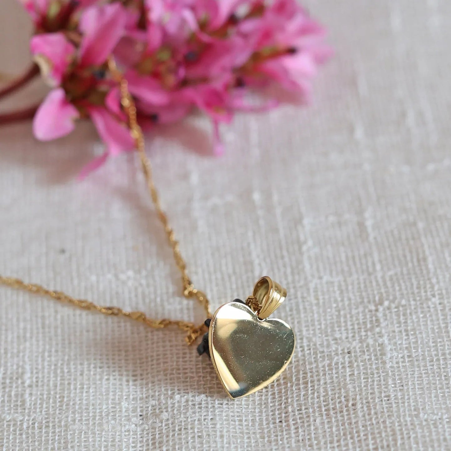 Collier A cœur ouvert en acier doré - vue zoom dos sur pendentif cœur strié personnalisé et chaîne torsadée.