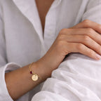 Bracelet Mon choix doré, bijou personné avec la lettre J en acier inoxydable avec médaillon gravé "Mon choix" et couleur de naissance rouge, porté au poignet.