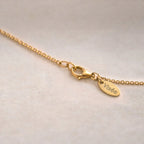 Gros plan sur le fermoir mousqueton du bracelet personnalisé Mon choix avec petite médaille Visée, sur fond beige texturé