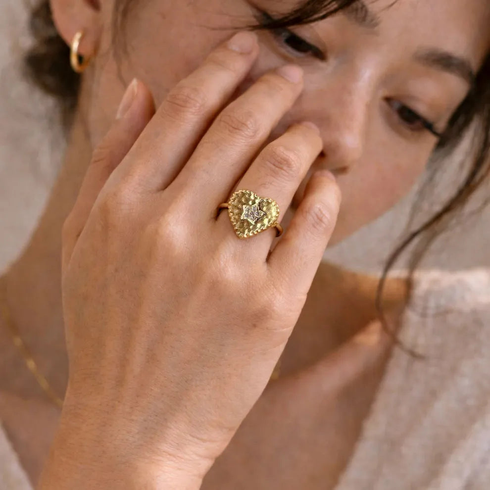 Bague coeur avec au milieu une étoile scintillante, portée sur la main- Cœur Battant Visée Bijoux