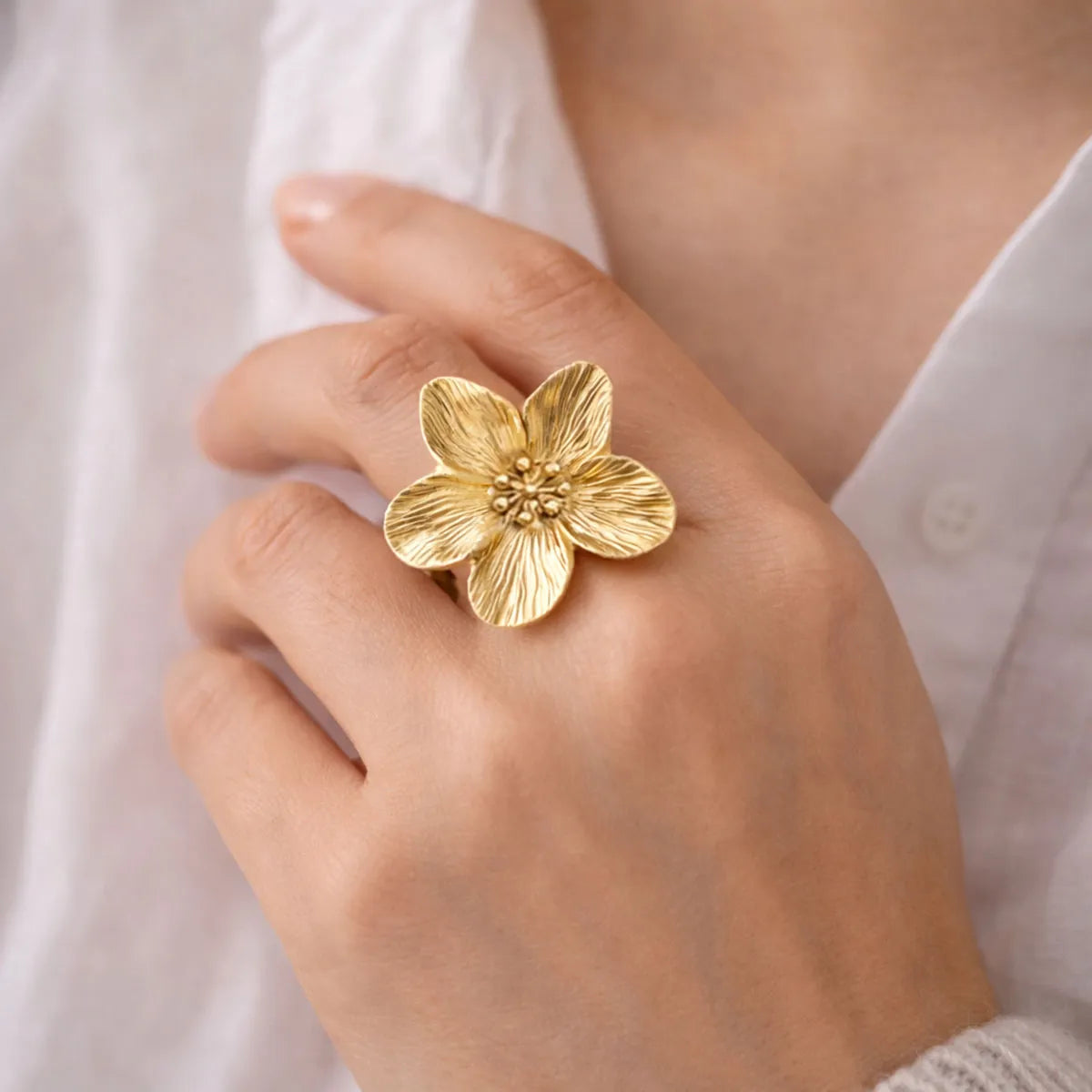 Bague ajustable fleur dorée portée sur une femme – Floraison Visée Bijoux