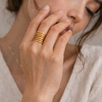 Bague multi-rangs dorée — portée à la main, lumière naturelle