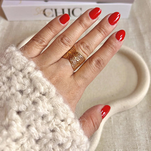 Bague Avenir ajustable, au design géométrique en acier inoxydable doré, portée au doigt.