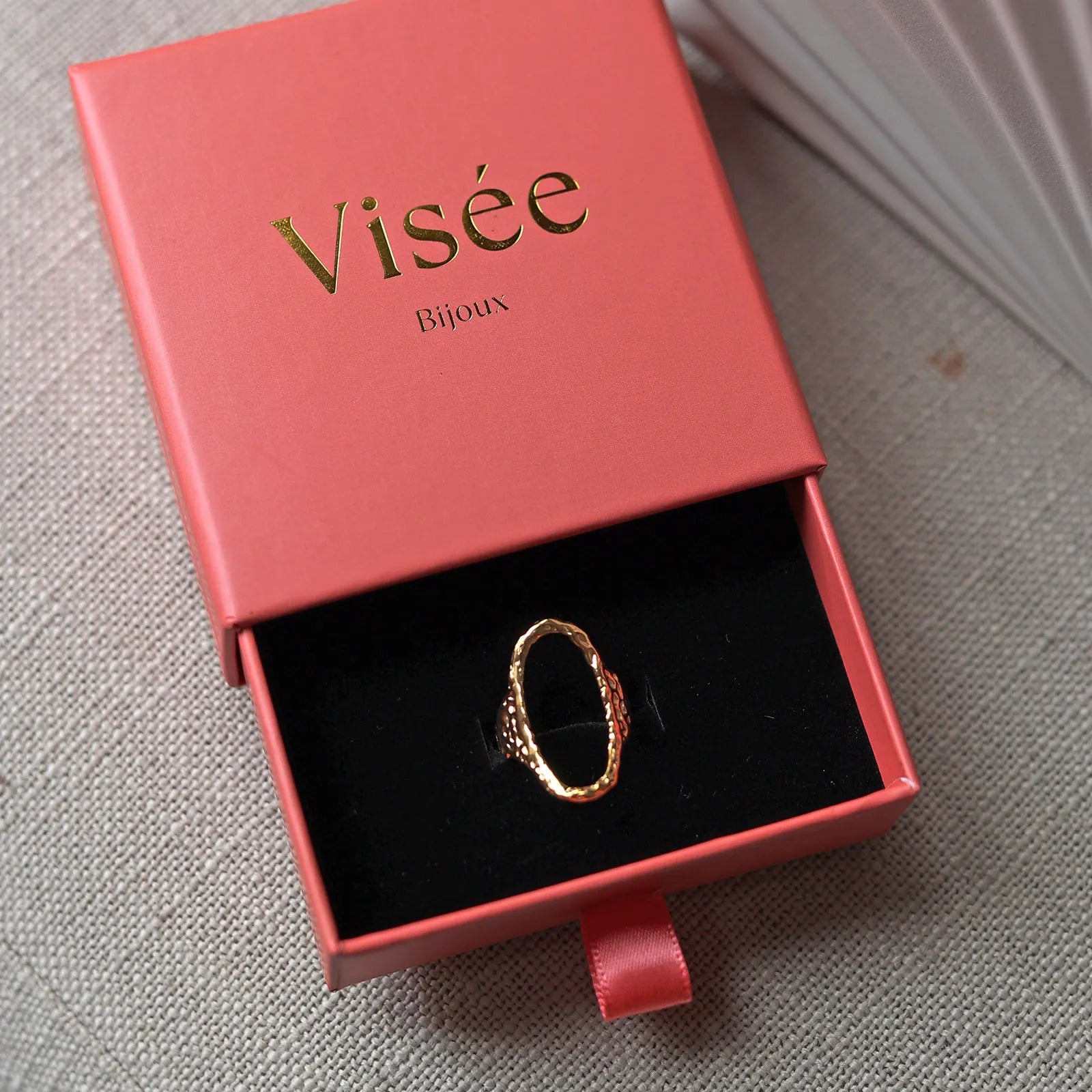 Bague Maintenant en acier inoxydable doré, ovale martelée et réglable, délicatement présentée dans son écrin Visée Bijoux. 