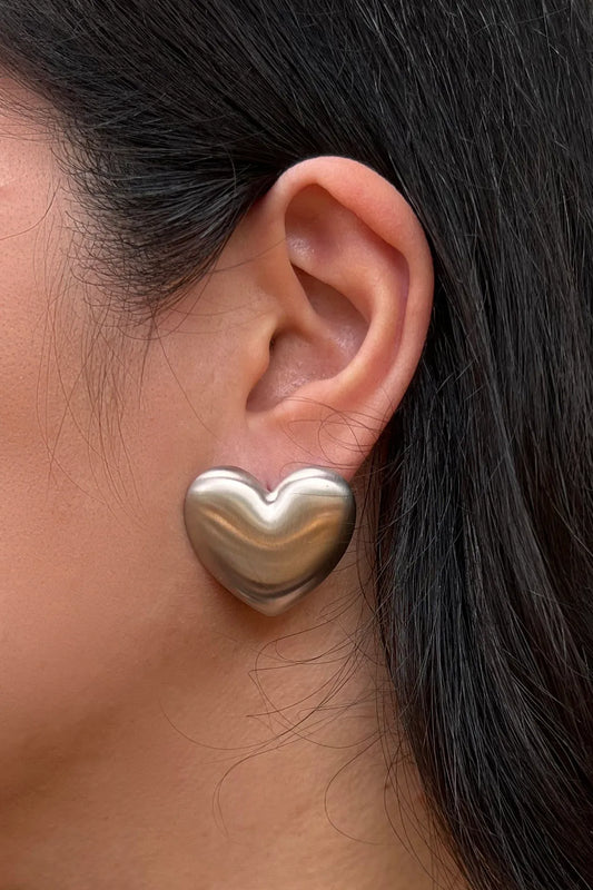 Boucles d’oreilles cœur argenté en acier inoxydable finition mat, un bijou élégant et intemporel pour un style raffiné et audacieux.