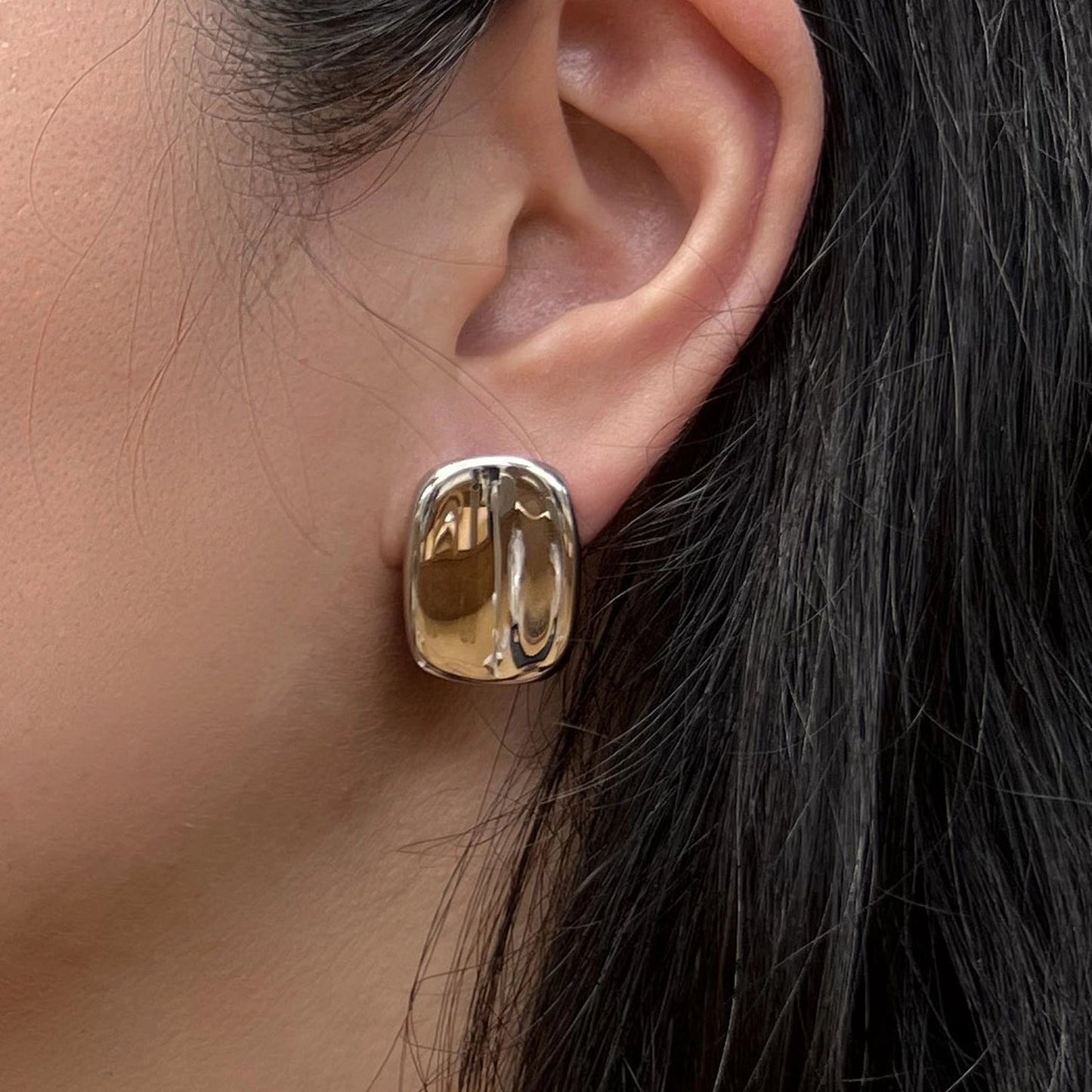Boucles d’oreilles Fierté rectangulaires argentées minimalistes en acier inoxydable, portées à l'oreille, vue de profil.