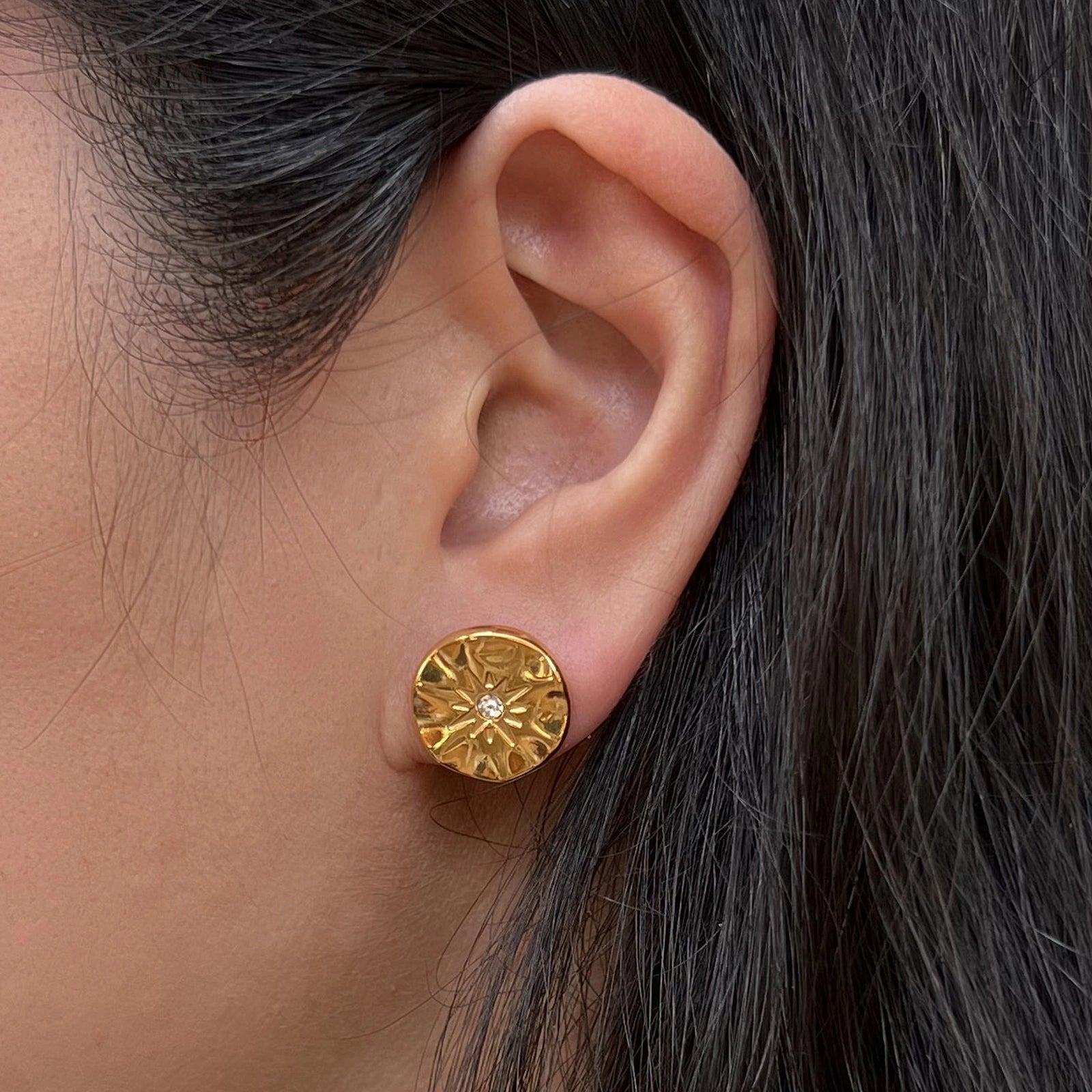 Boucles d’oreilles dorées motif étoile en acier inoxydable, serties d'un zircon lumineux - modèle Céleste porté à l'oreille, par Visée Bijoux.