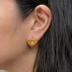 Boucles d'oreilles Promesse, en forme de cœur ornées d'une étoile, en acier inoxydable doré, portées à l'oreille.
