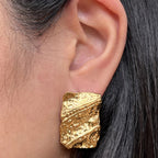 Boucles d’oreilles rectangulaires dorées– Relief Visée Bijoux, portées sur un mannequin