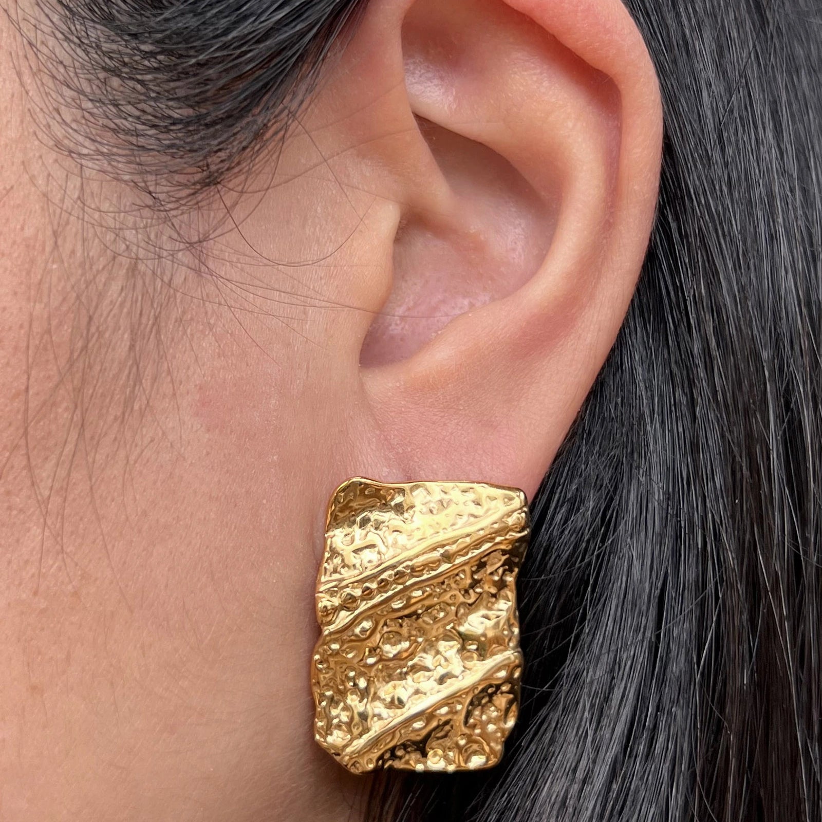 Boucles d’oreilles rectangulaires dorées– Relief Visée Bijoux, portées sur un mannequin
