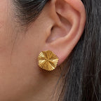 Boucles d'oreilles "Ma raison" en acier doré, au motif floral, portées à l'oreille.