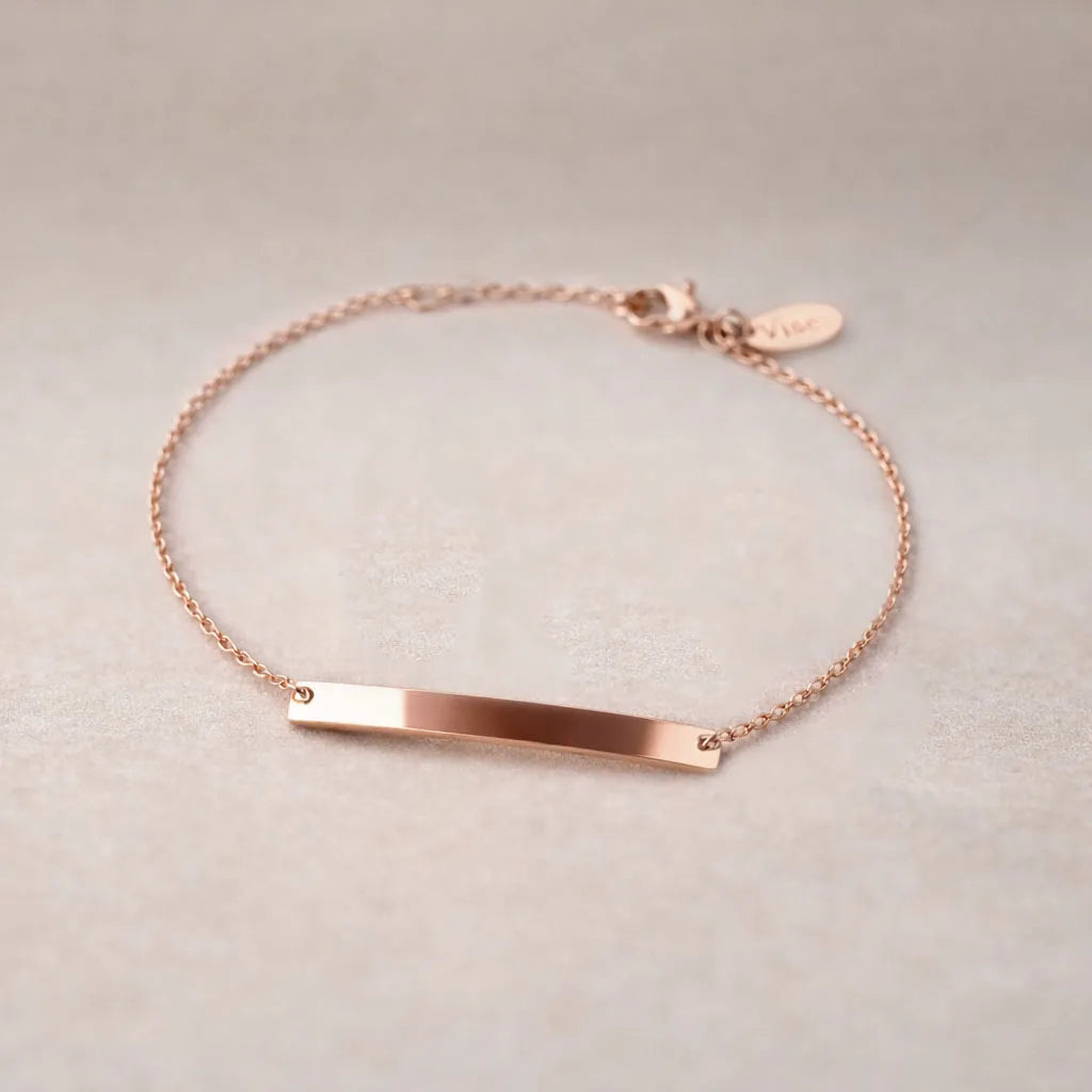 Bracelet gourmette Lien en acier inoxydable or rose,  personnalisable, posé sur un fond beige texturé.