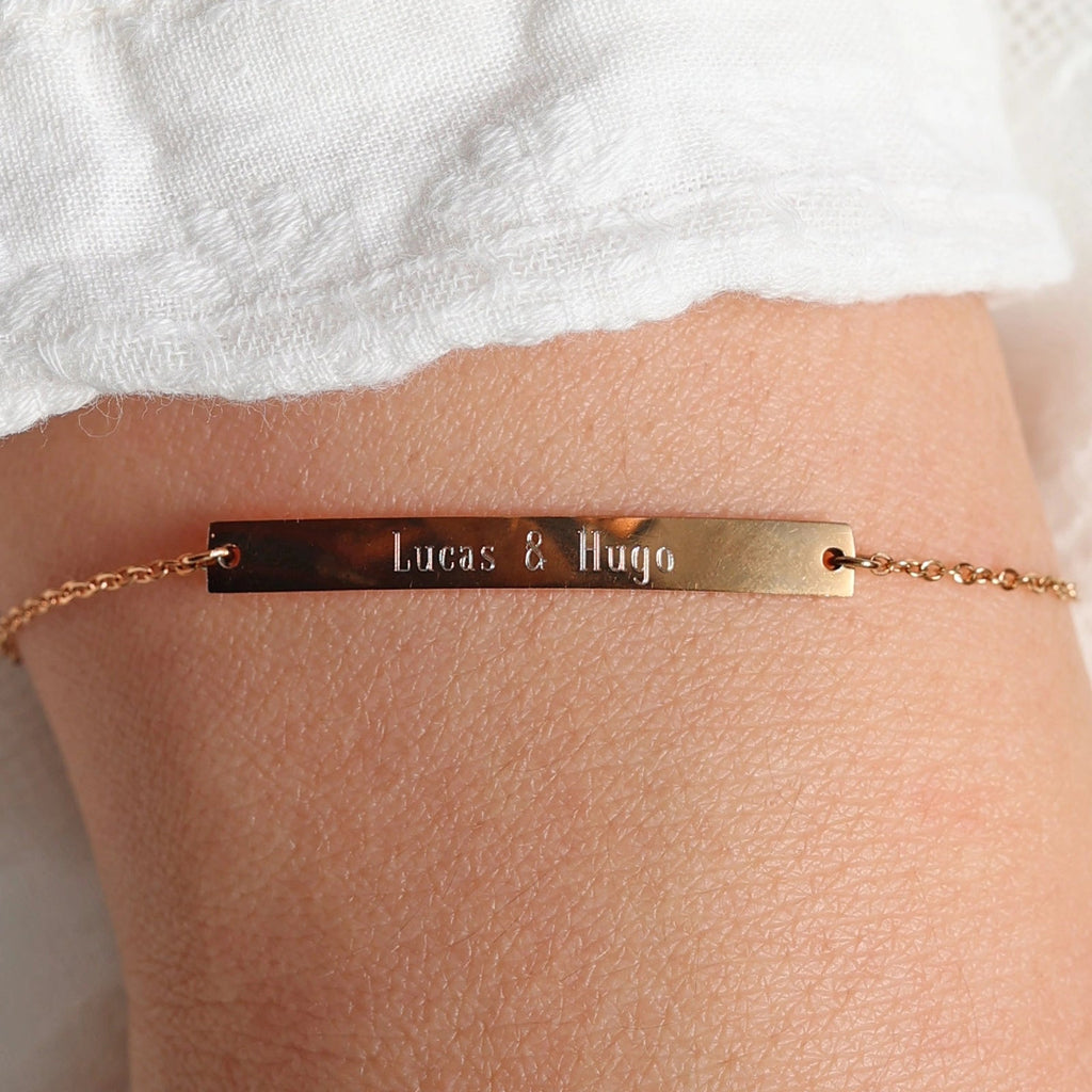 Bracelet gourmette "Sincérité" en acier inoxydable rosé,  personnalisé des noms "Lucas & Hugo", porté autour du poignet.