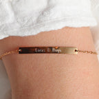 Bracelet gourmette "Sincérité" en acier inoxydable rosé,  personnalisé des noms "Lucas & Hugo", porté autour du poignet.