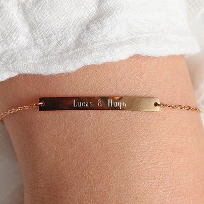 Bracelet gourmette "Sincérité" en acier inoxydable rosé,  personnalisé des noms "Lucas & Hugo", porté autour du poignet.