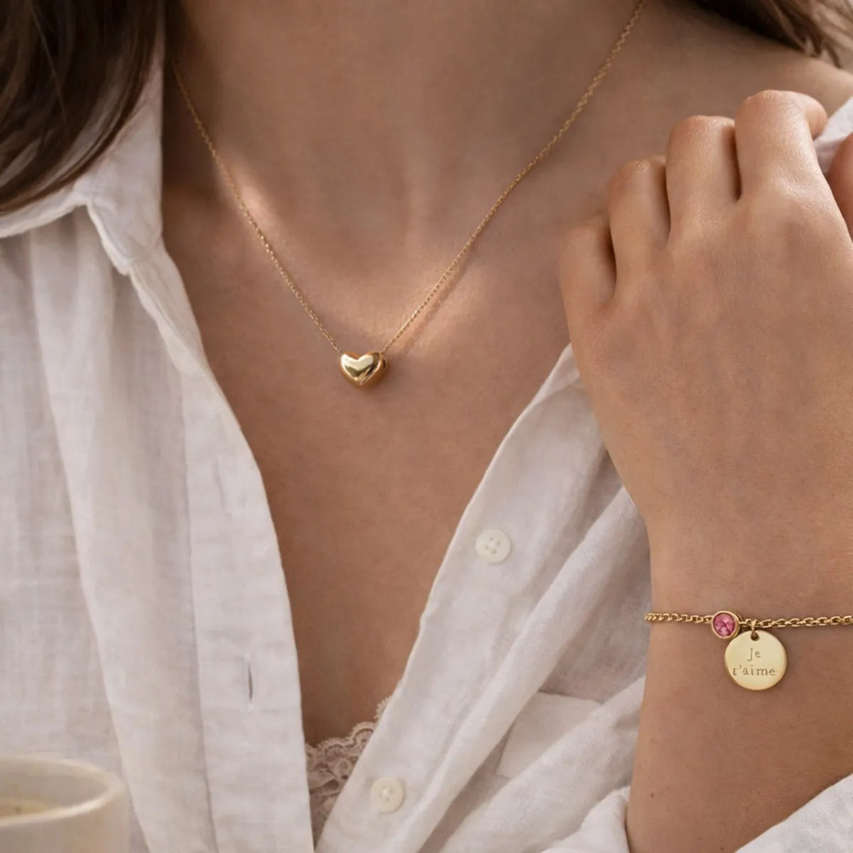 Coffret Signature – Bracelet personnalisé avec la gravure Je t'aime et Couleur de naissance rose & collier cœur Visée Bijoux, portés par une belle mannequin brune.
