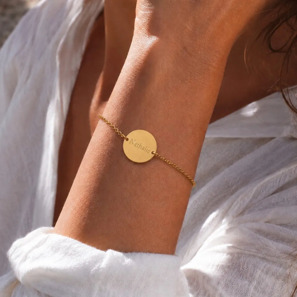 Bracelet médaille ronde gravée 2 faces — Aimé Visée Bijoux, portée au poignet, personnalisé avec le prénom Nathalie