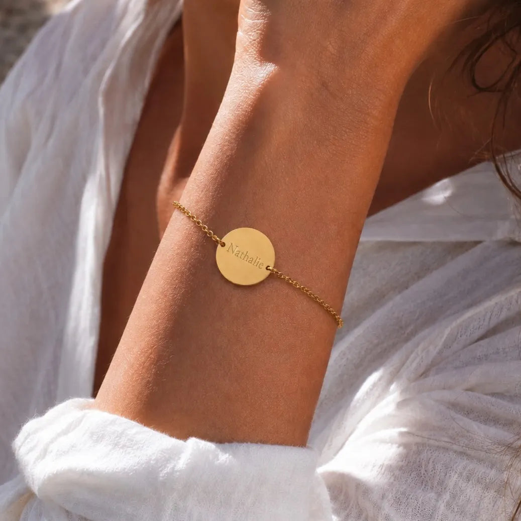 Bracelet médaille ronde gravée 2 faces — Aimé Visée Bijoux, portée au poignet, personnalisé avec le prénom Nathalie