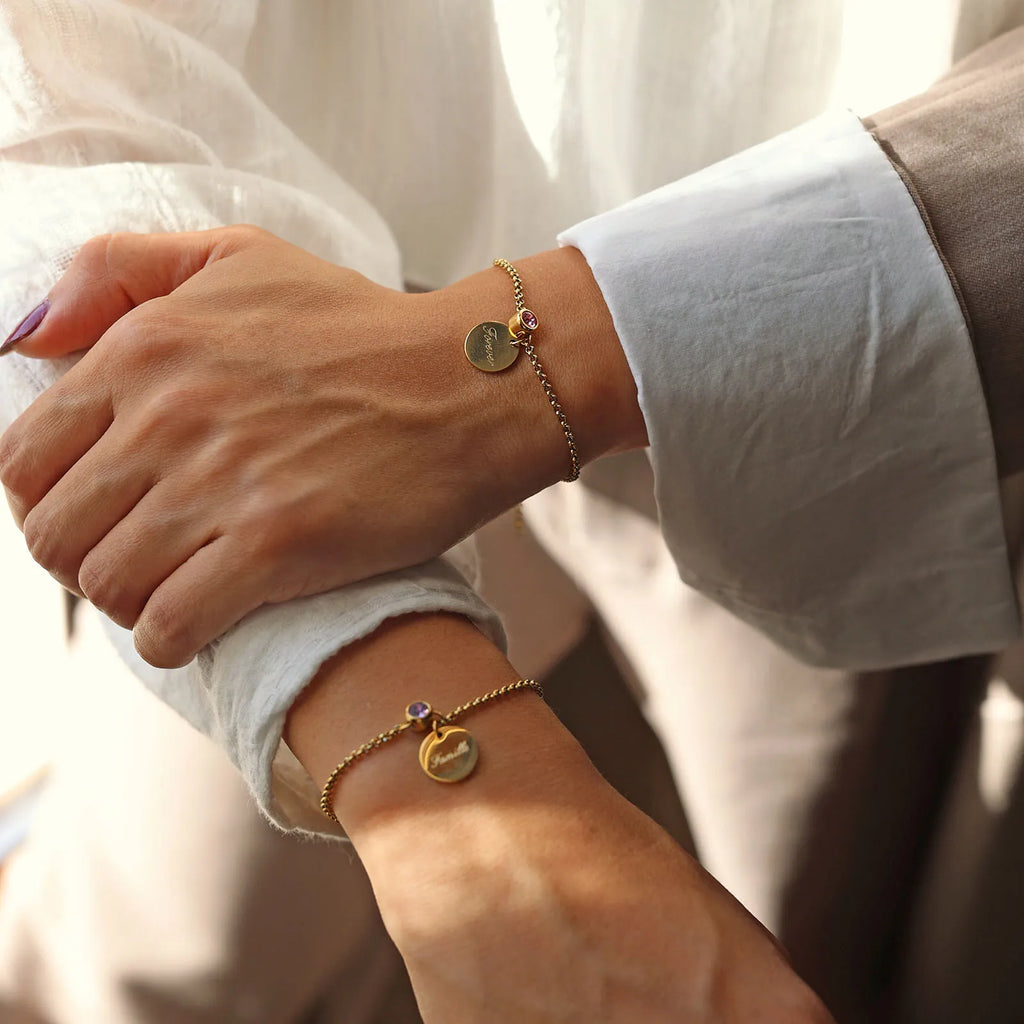 Bracelets Mon choix doré, bijoux personnalisables en acier inoxydable avec médaillon gravé "Famille" et "Forever" et pierres de naissance, portés au poignet.