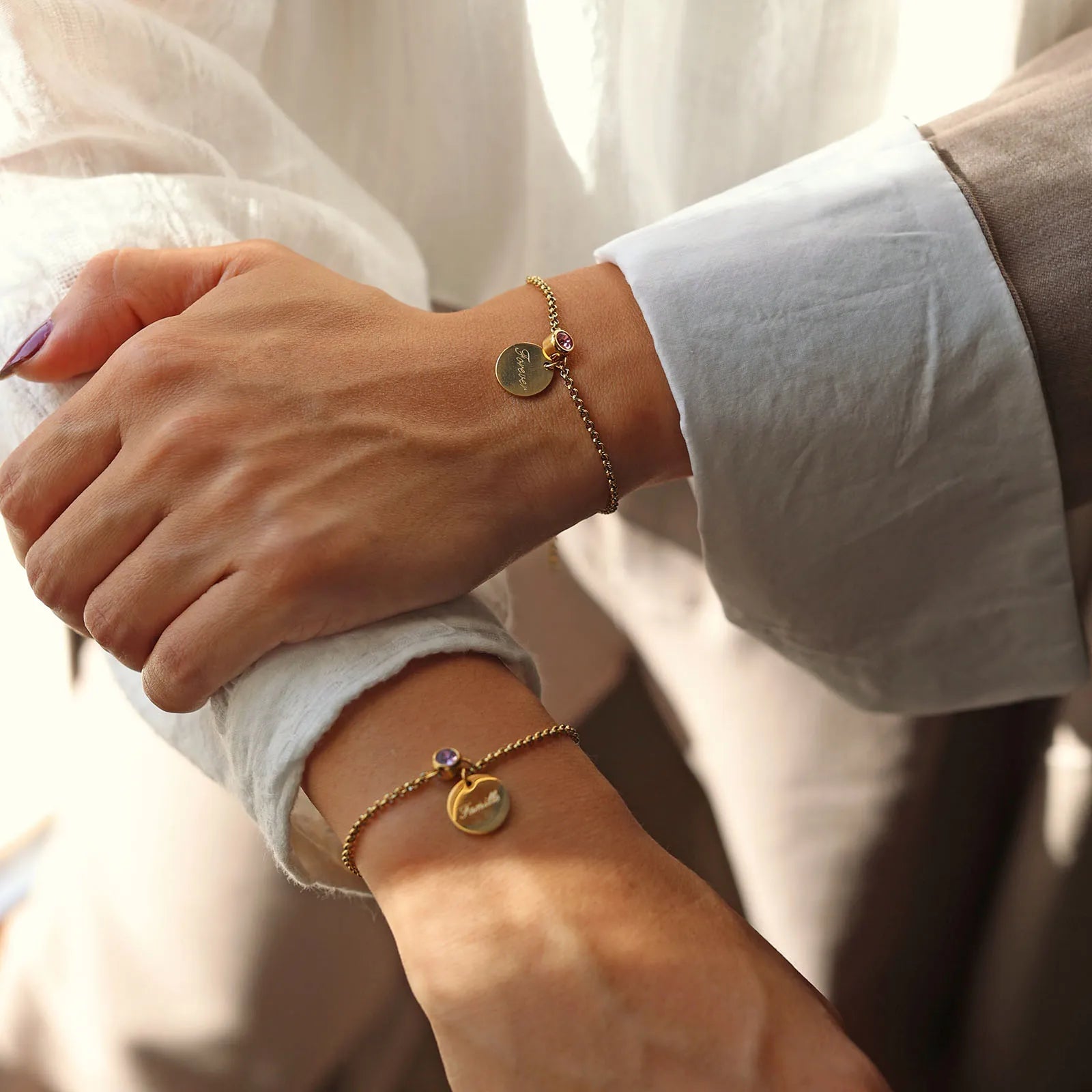 Bracelets Mon choix doré, bijoux personnalisables en acier inoxydable avec médaillon gravé "Famille" et "Forever" et pierres de naissance, portés au poignet.