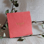 Chamoisine Visée en suédine corail, pour l'entretien délicat des bijoux, photographiée sur un fond beige.