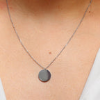 Collier "Reflet" avec médaille ronde personnalisé en acier inoxydable argenté, porté autour du cou.