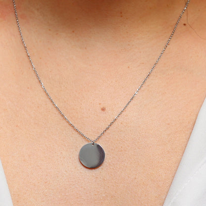 Collier "Reflet" avec médaille ronde personnalisé en acier inoxydable argenté, porté autour du cou.