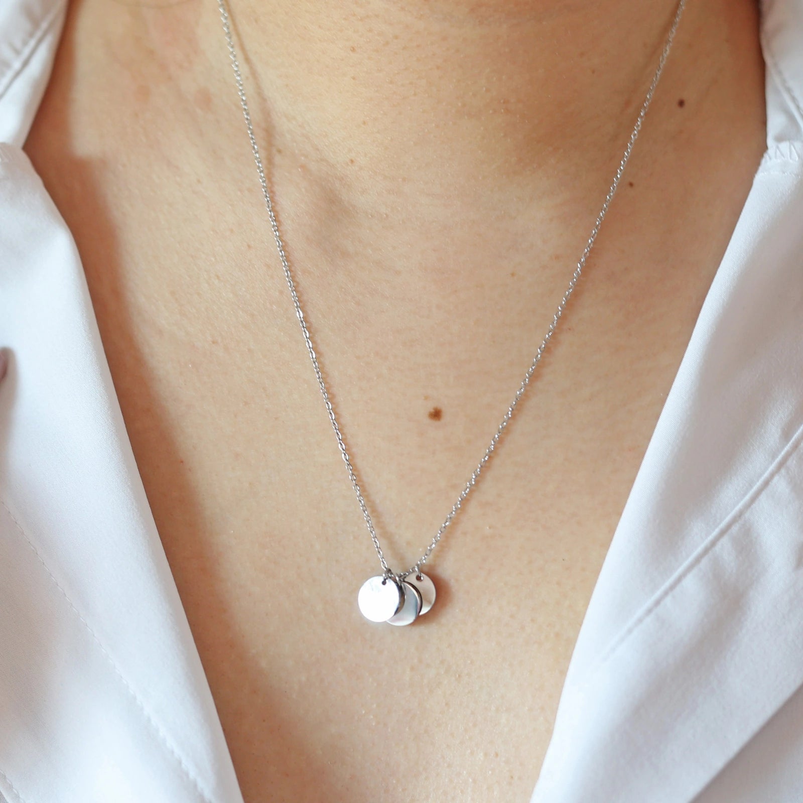 Collier "Inspiration" en acier inoxydable argenté, composé de trois médaillons personnalisables, porté autour du cou.