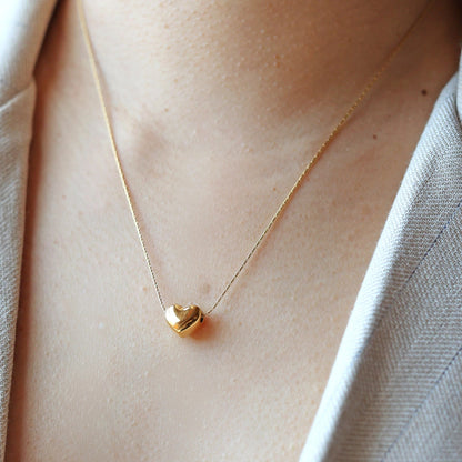 Collier Authentique avec pendentif cœur minimaliste personnalisable, en acier inoxydable doré, porté autour du cou.