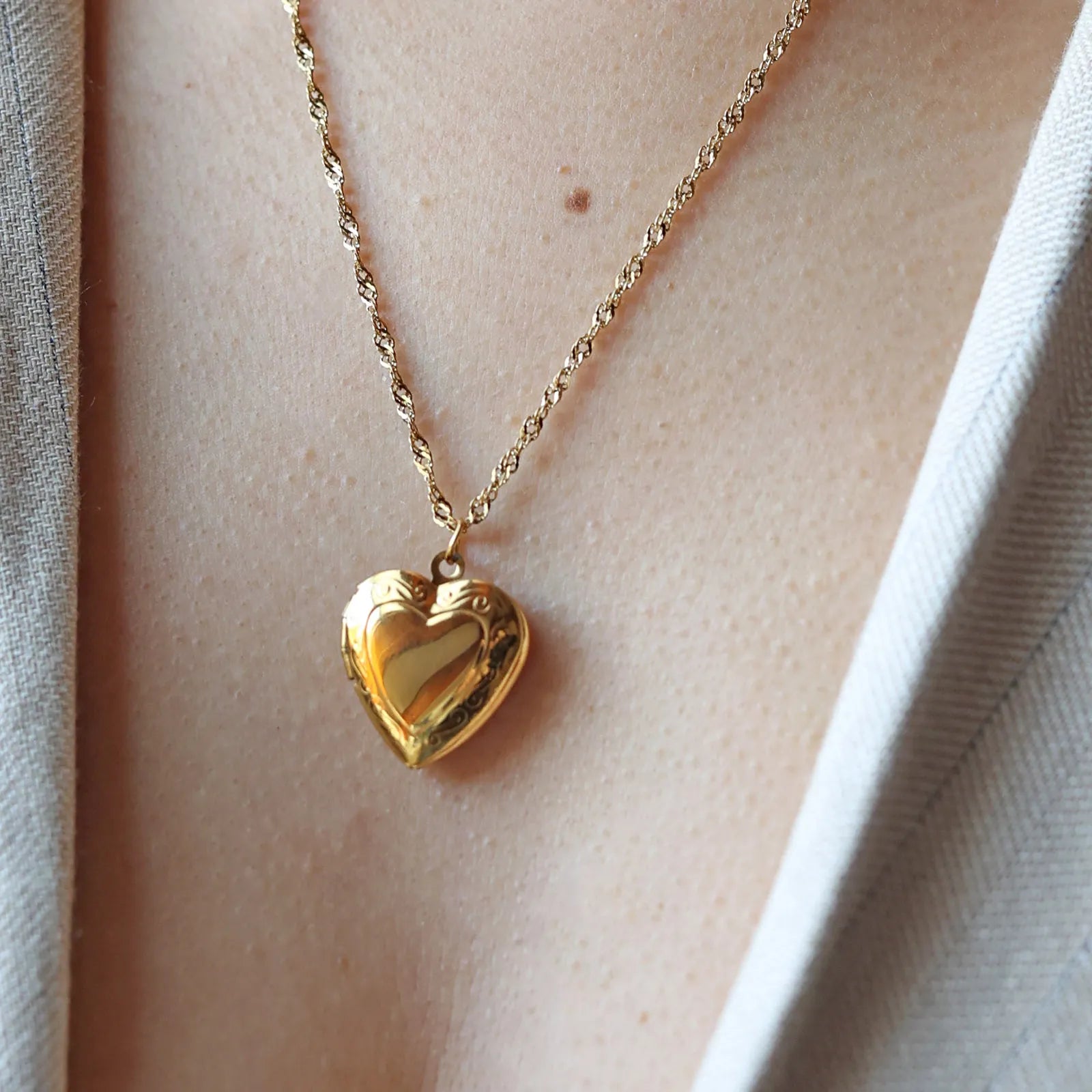 Collier Précieux médaillon cœur en acier doré avec photo souvenir à personnaliser, porté autour du cou.