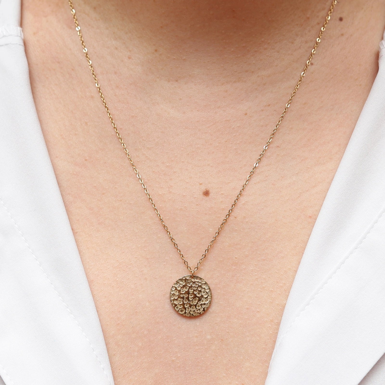 Collier Renaissance doré, médaille ronde martelée à graver, porté autour du cou. 