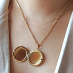 Collier "Ce jour là" avec médaillon rond personnalisable en acier doré, porté autour du cou. 