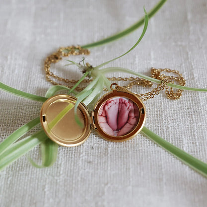 Collier "Ce jour là" avec médaillon rond personnalisable en acier doré, présenté sur un fond beige texturé.