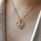 Collier Chérie en acier doré avec pendentif coeur strié orné d'un zircon central, personnalisable, porté autour du cou.