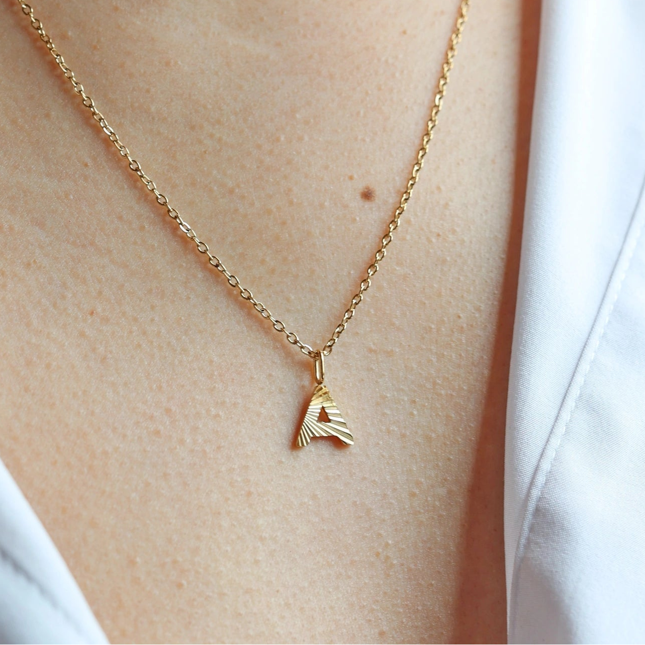 Collier lettre initiale striée doré, lettre A– Grâce Visée Bijoux, portée sur mannequin.