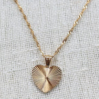 Collier A coeur ouvert en acier doré - vue zoom sur pendentif cœur strié personnalisé et chaîne torsadée.