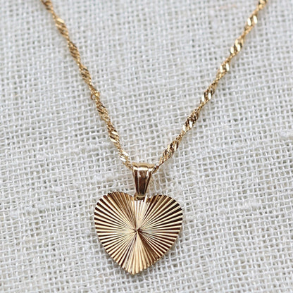 Collier A coeur ouvert en acier doré - vue zoom sur pendentif cœur strié personnalisé et chaîne torsadée.