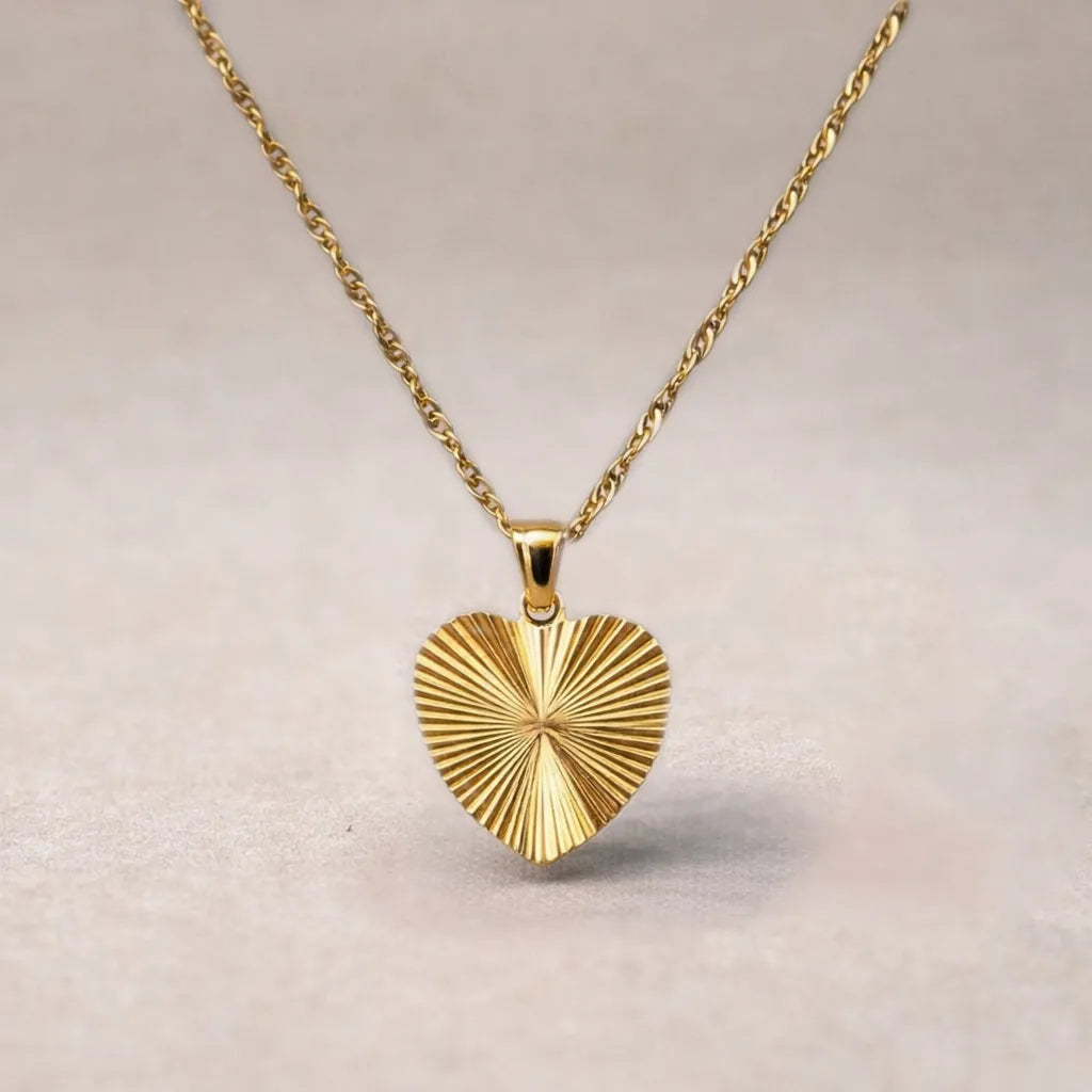 Collier A cœur ouvert en acier doré - vue zoom sur pendentif cœur strié personnalisable au dos et chaîne torsadée.